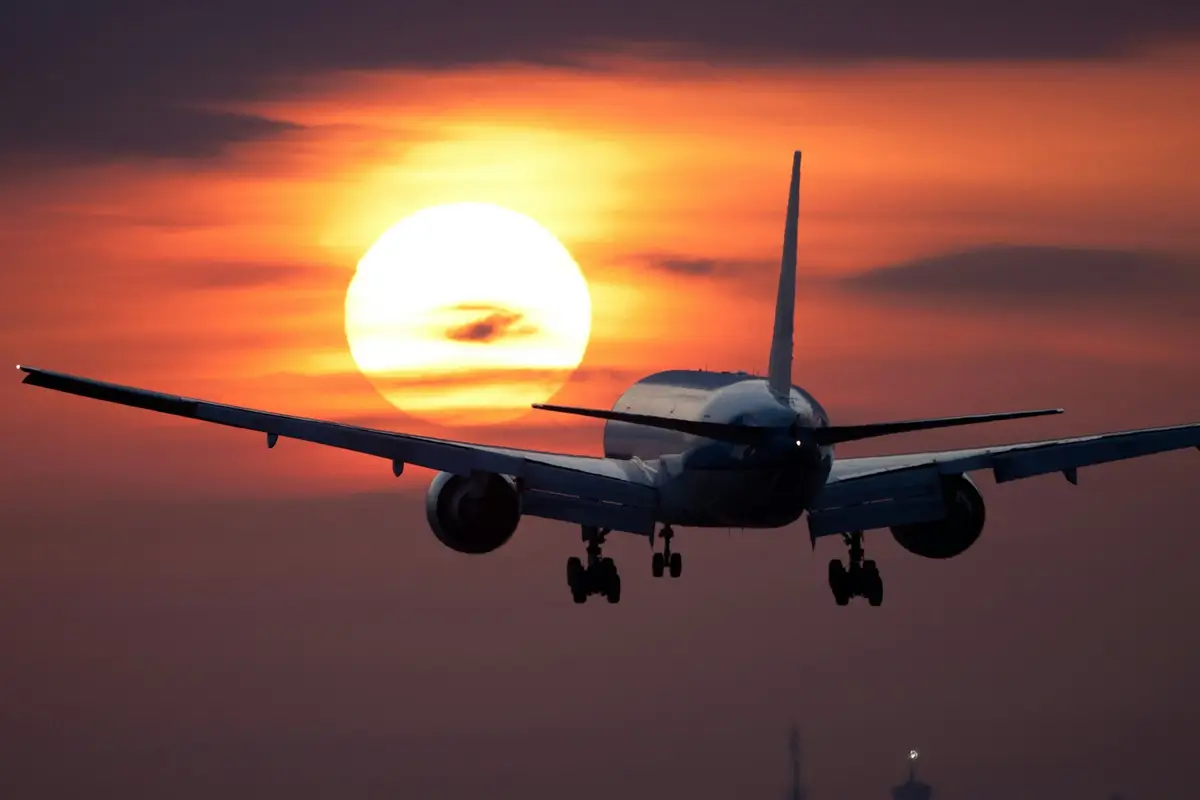 Airplane on approach to land against the sunset
