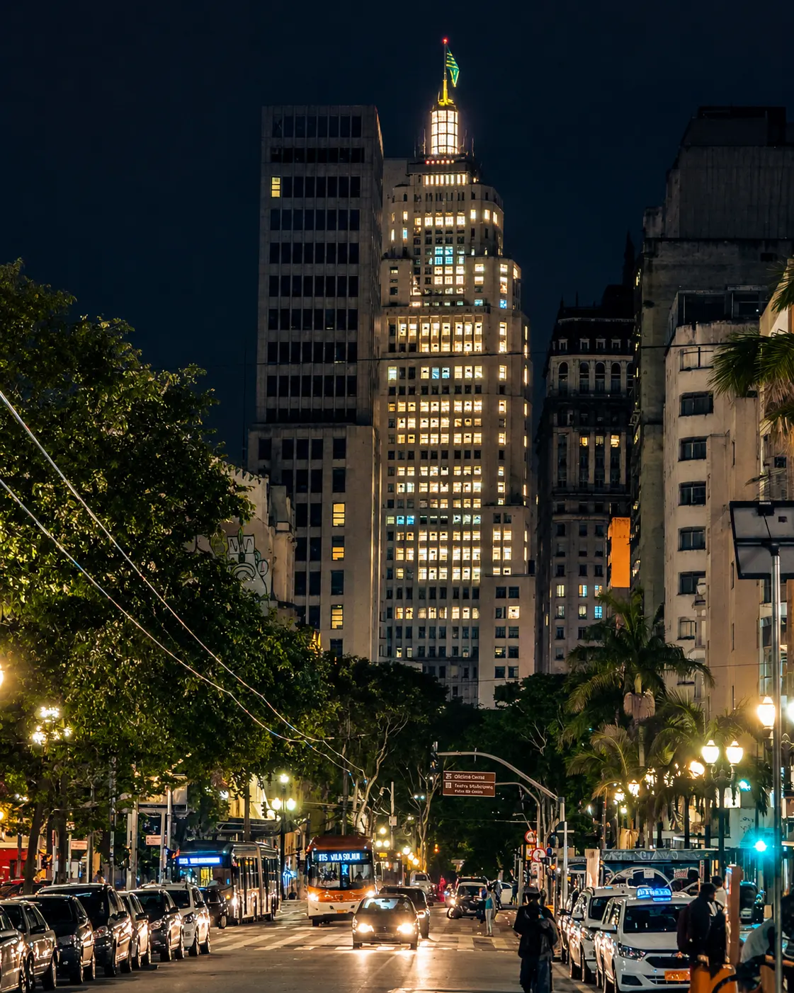 Avenue at night leading to the illuminated Farol Santander building, in downtown São Paulo